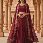 maroon lehenga set includes a solid crop top, a flared skirt, and an embroidered long cape.