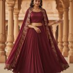 maroon lehenga set includes a solid crop top, a flared skirt, and an embroidered long cape.